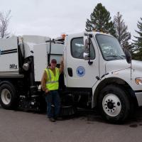Picture of a street sweeper truck with Joe Levine a Public Works - Street Division employee