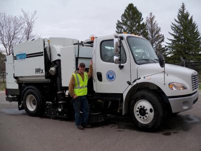 Picture of a street sweeper truck with Joe Levine a Public Works - Street Division employee